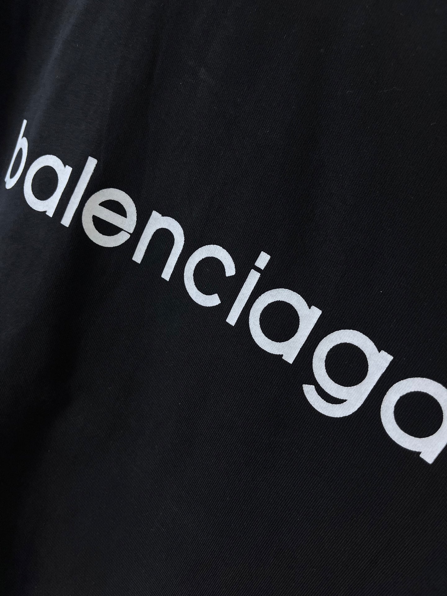Dark navy T-shirt fabric close-up with 'balenciaga' wordmark
