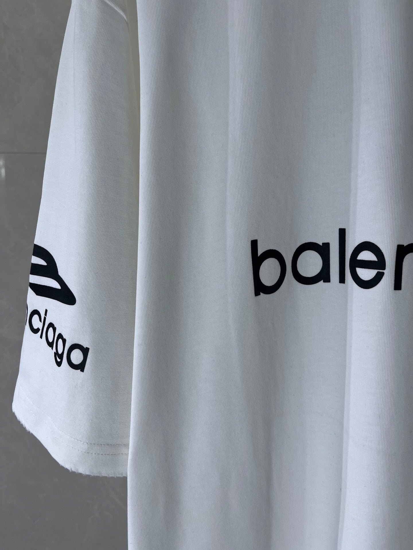 White T-shirt with partial Balenciaga logo print on hem, short sleeves
