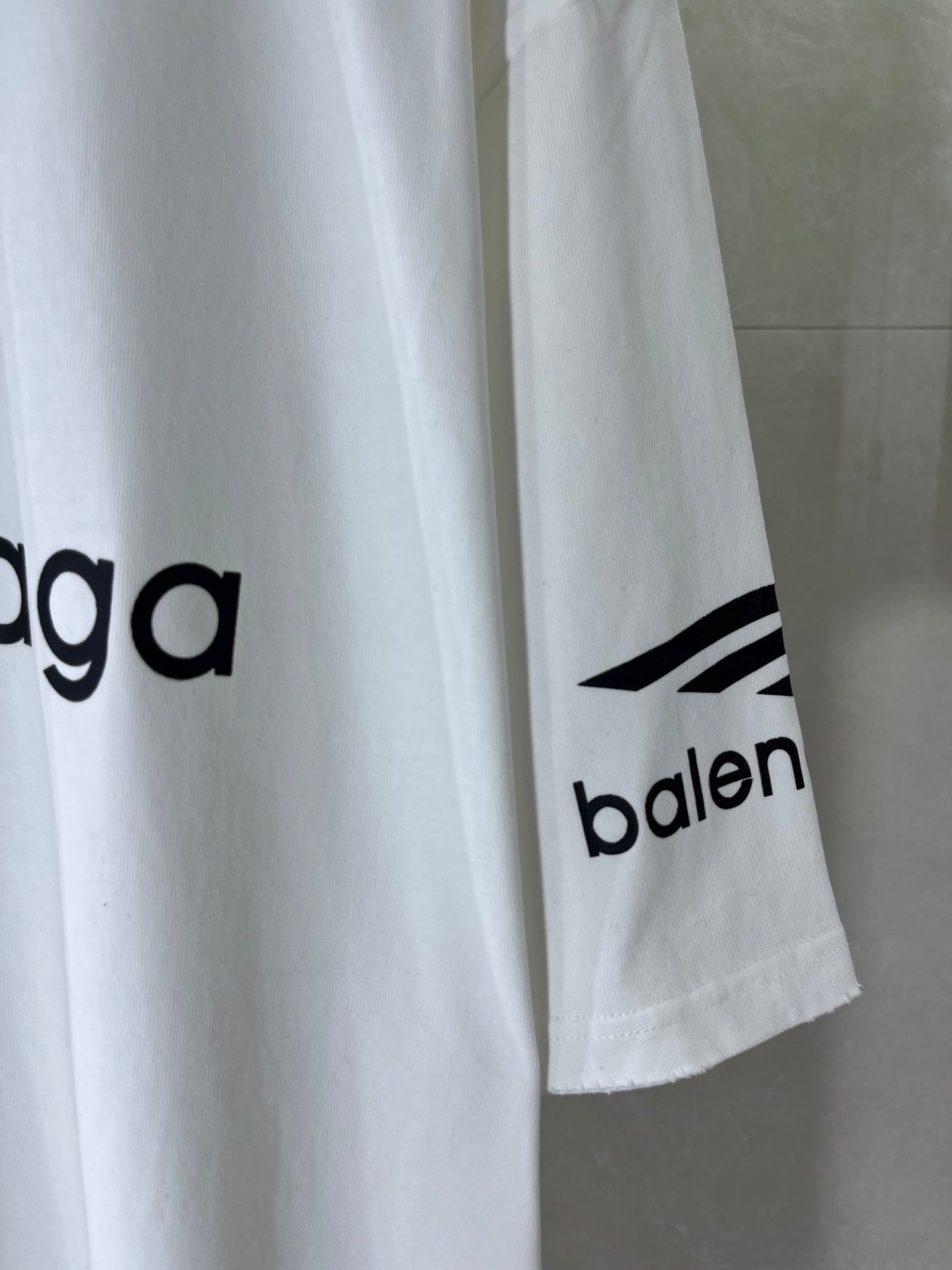 White T-shirt sleeve and side hem with Balenciaga logo print
