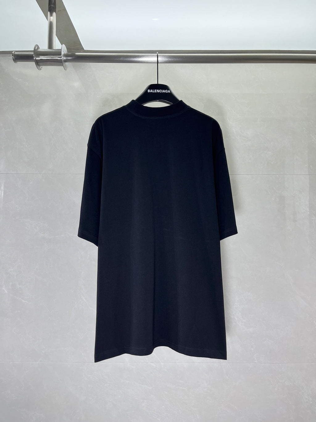Black short-sleeve T-shirt on hanger, minimal front design