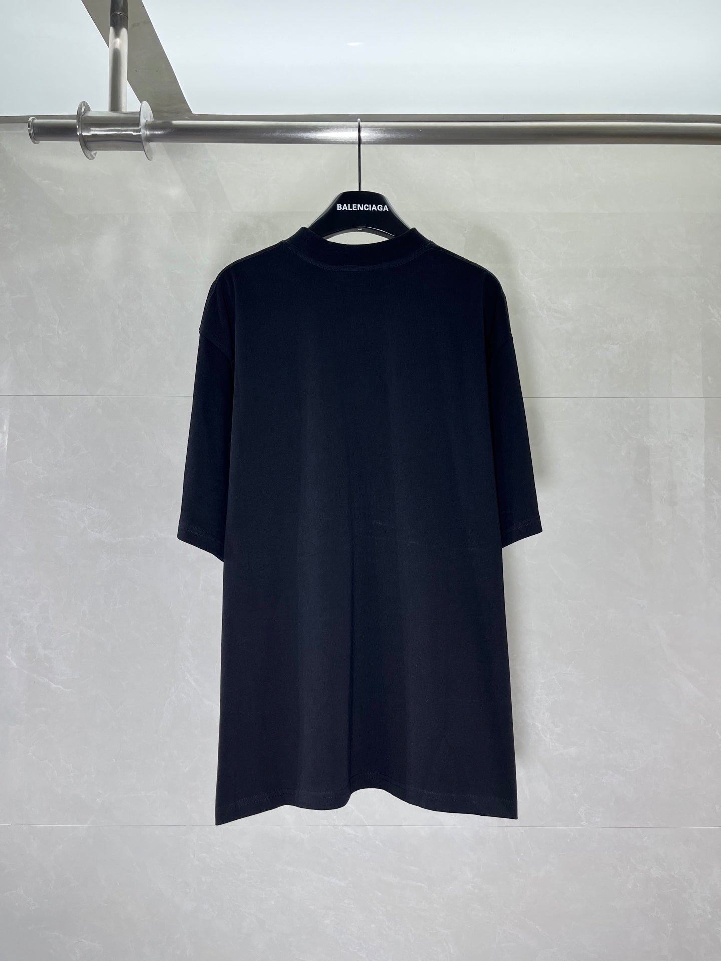 Black short-sleeve T-shirt on hanger, minimal front design