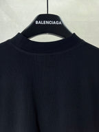 Black T-shirt collar and upper front panel on hanger with BALENCIAGA label