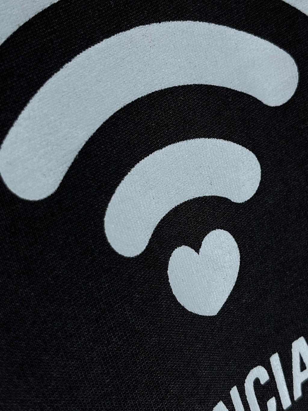 Black T-shirt close-up of large white Wi‑Fi icon with small heart detail