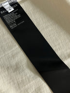 Inside care label on white short-sleeve T-shirt, black fabric tag with text