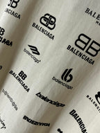 Close-up of white fabric with Balenciaga logo and emblem prints