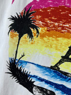 Balenciaga T-shirt graphic close-up: palm trees over colorful sunset waves