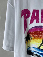 Balenciaga white T-shirt sleeve with partial magenta “PARIS” text and palm art