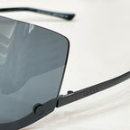 Gucci glasses close-up: black frame with blue tinted lens, gold-tone arm