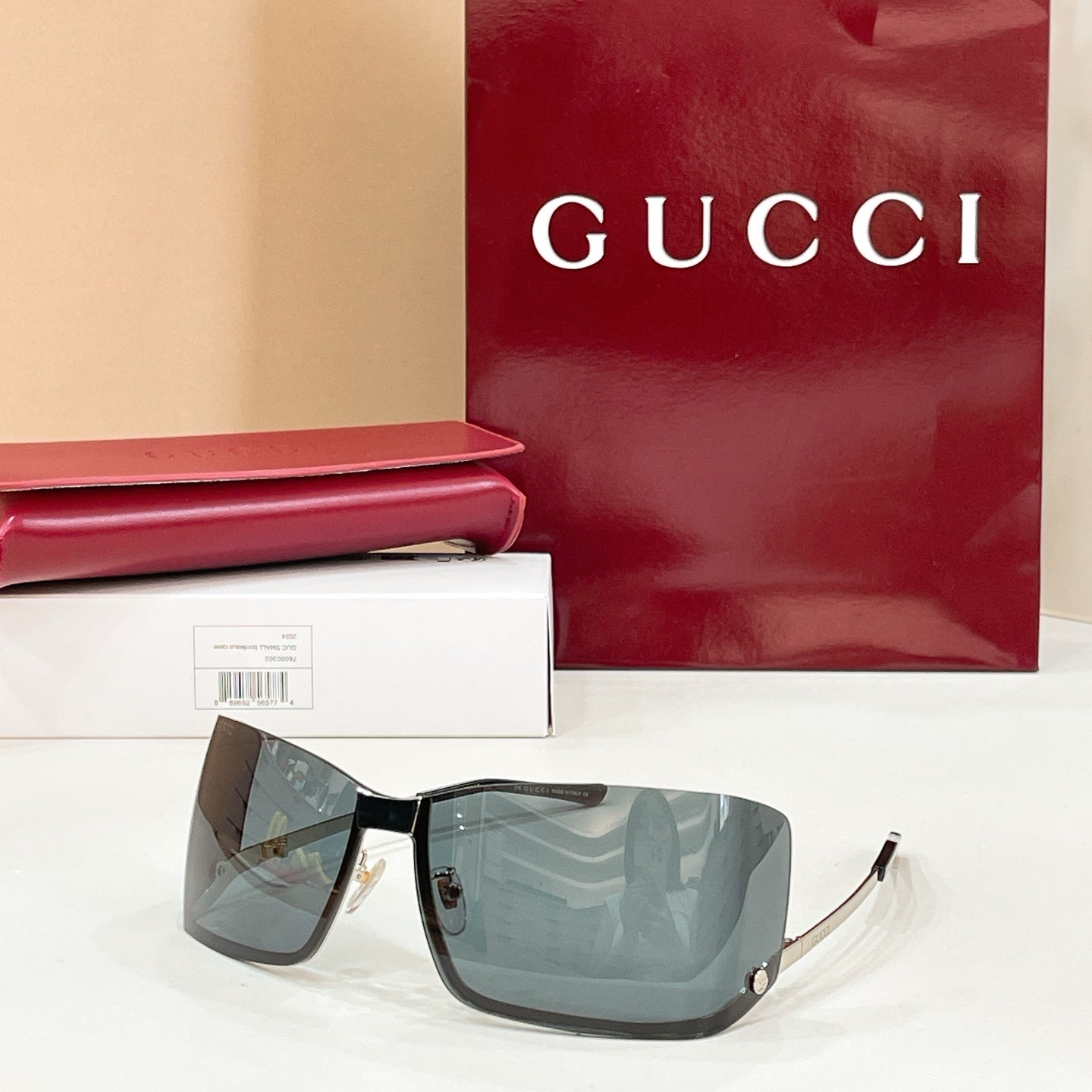 Gucci glasses with blue-gray tinted lenses, black frame, and gold-tone details