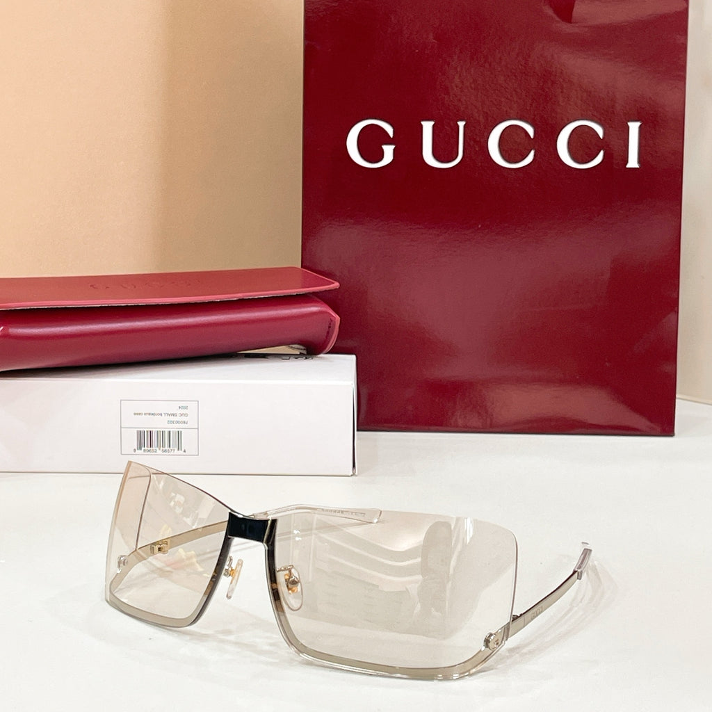 Gucci glasses with light-tinted lenses, black frame, and gold-tone details