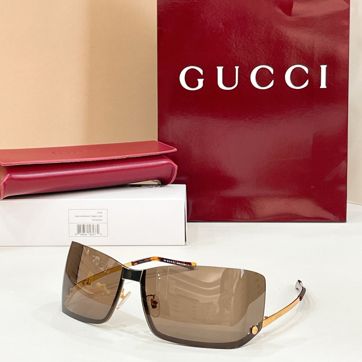 Gucci glasses with brown-tinted lenses, black frame, and gold-tone details