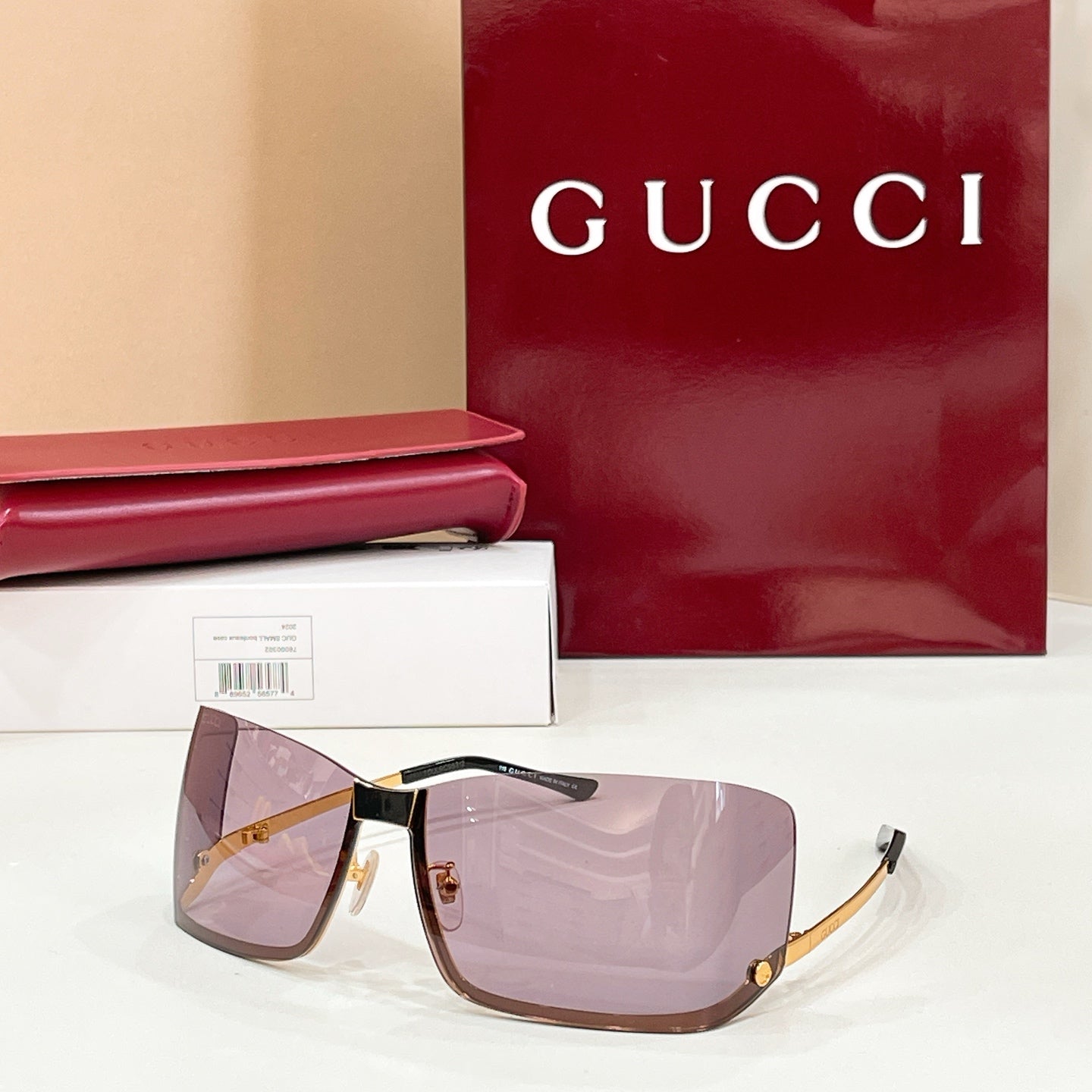 Gucci glasses with purple-pink tinted lenses, black frame, and gold-tone details