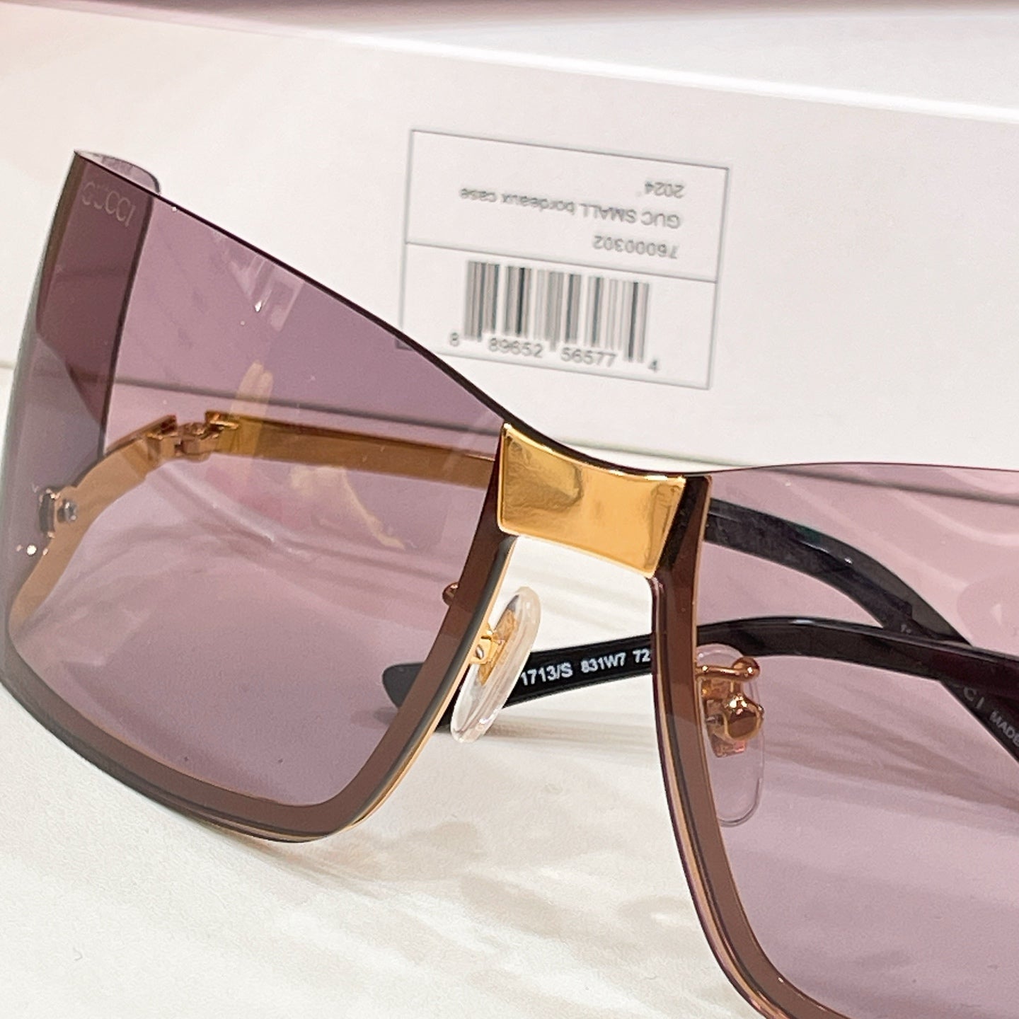 Gucci square sunglasses angled view with gold bridge and mauve tinted lenses