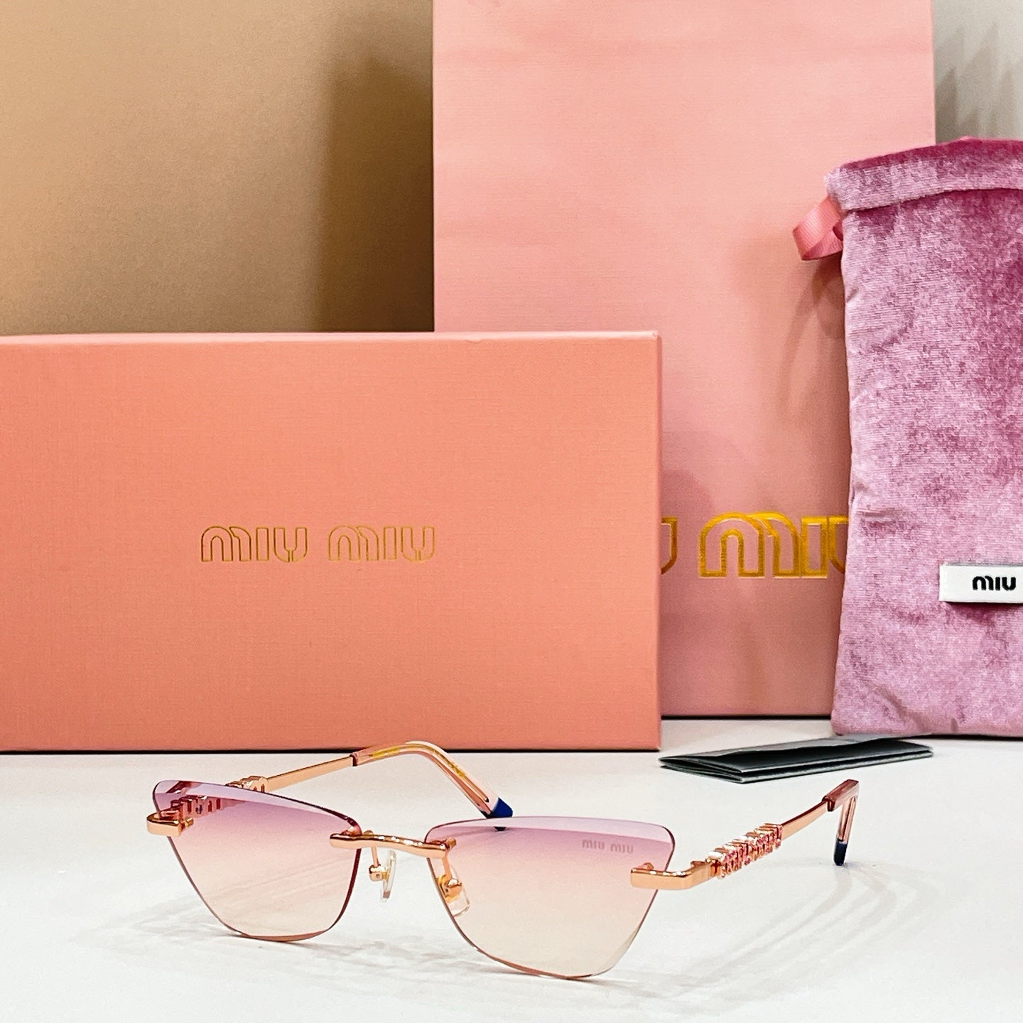 MiuMiu cat-eye glasses, pale pink-tinted lenses with gold frames and blue-tipped temples