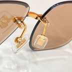 Sunglasses close-up: gold ornamented hinge with clear decorative lens piece