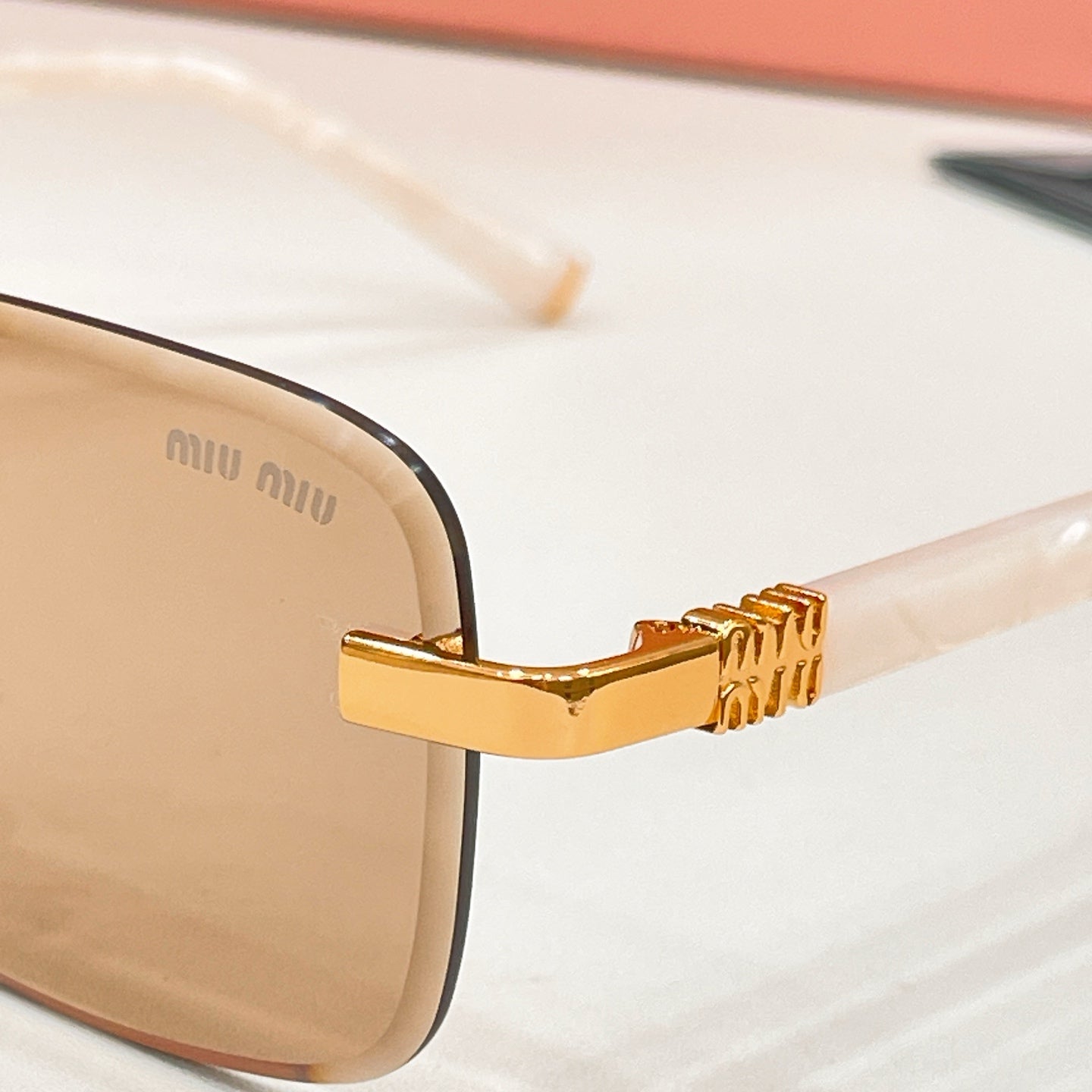 Sunglasses close-up: gold hinge and temple detail on dark frame