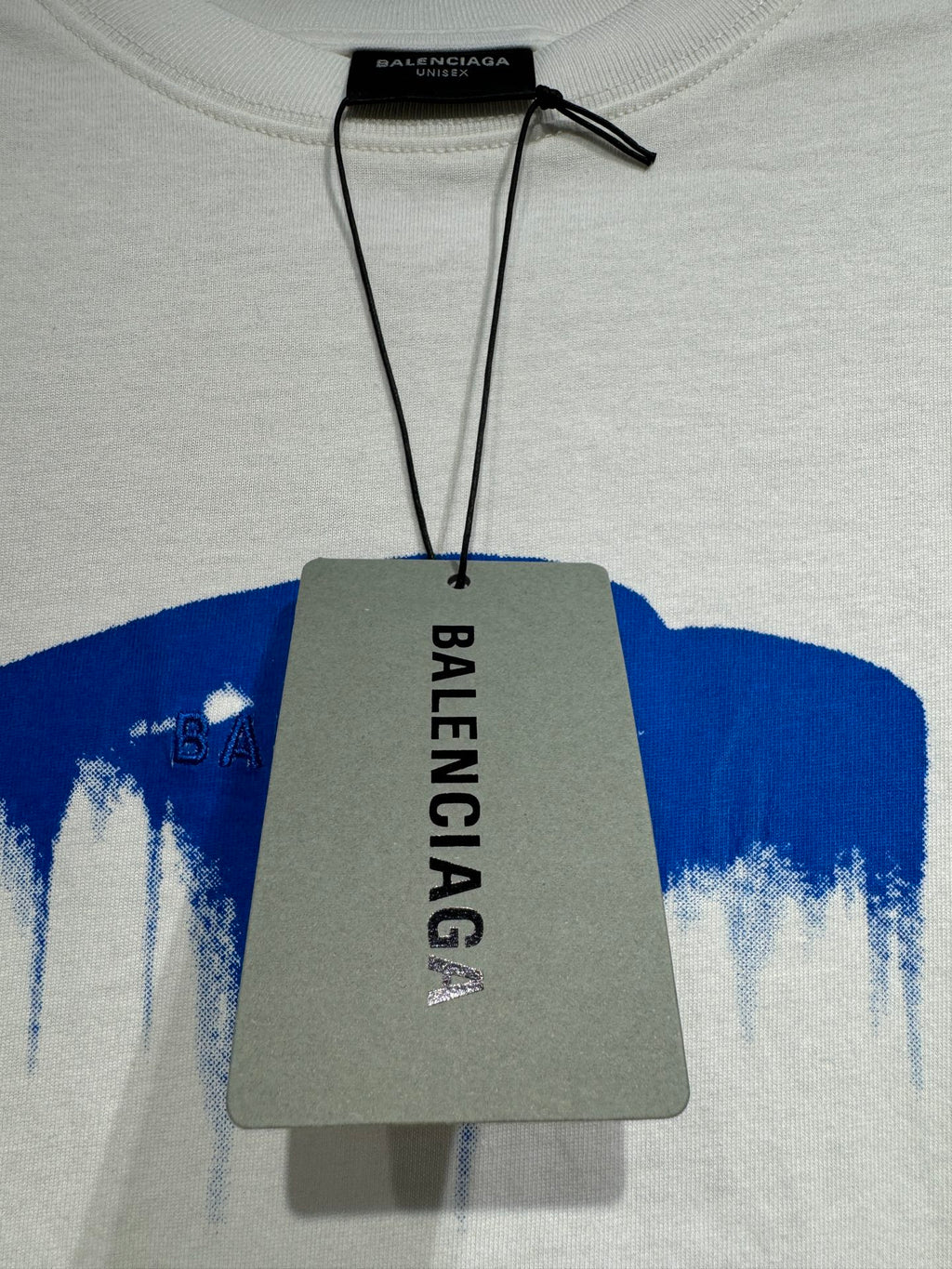 White Balenciaga T-shirt with black hang tag and blue drip logo on chest