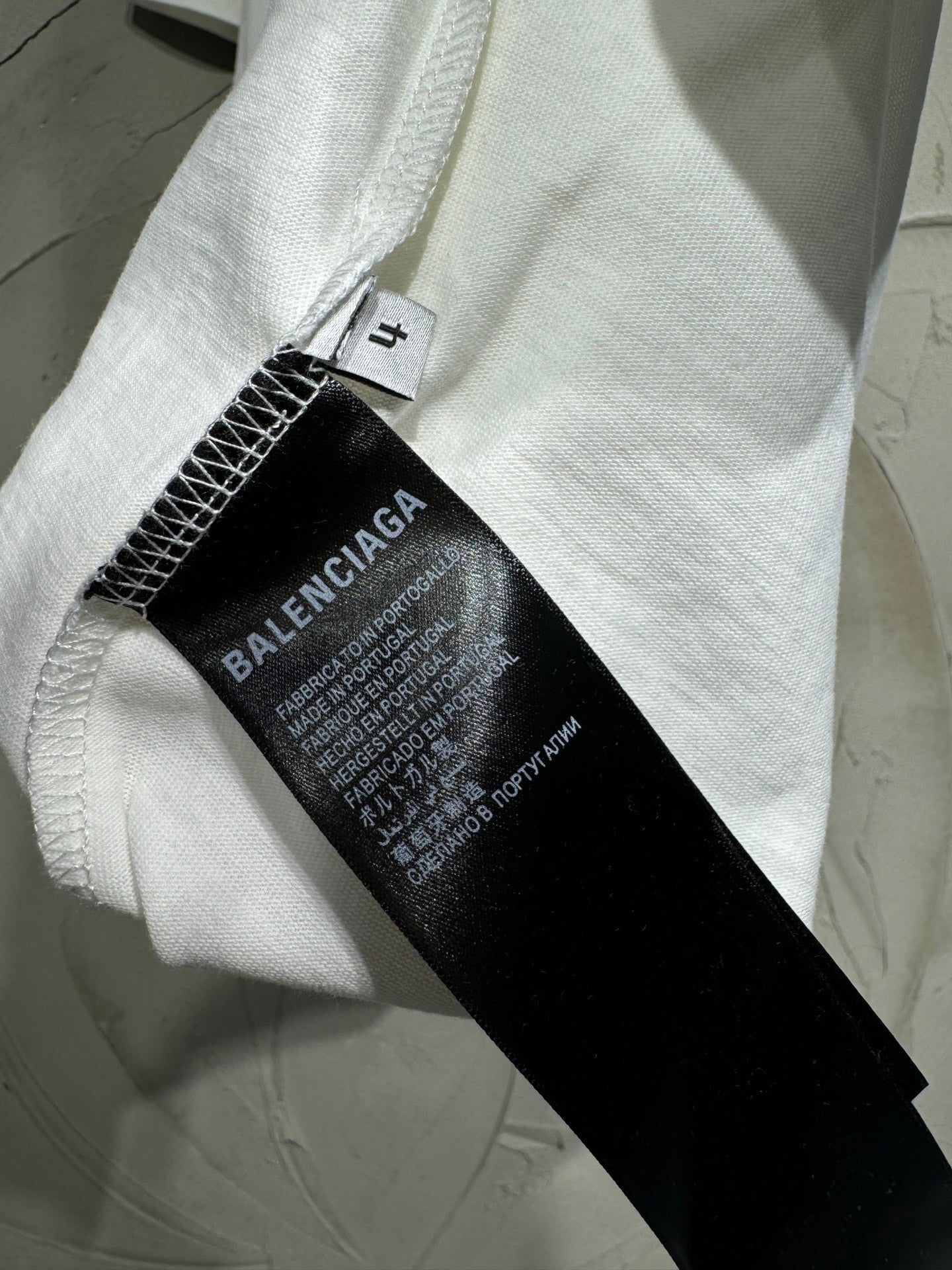 White Balenciaga T-shirt with black interior care label on stitched seam