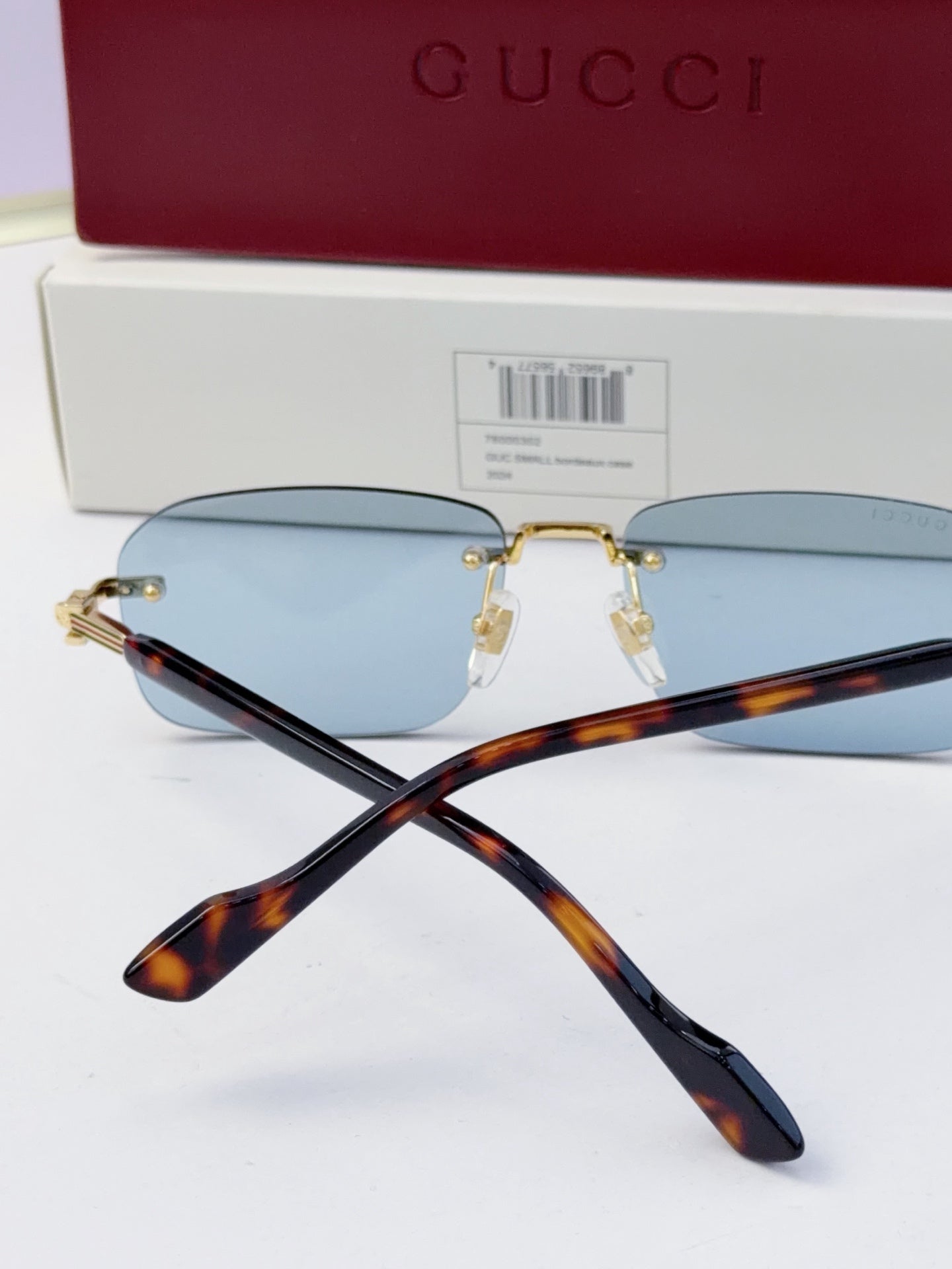 Gucci sunglasses close-up: blue mirrored lenses, gold-tone bridge, tortoiseshell temples