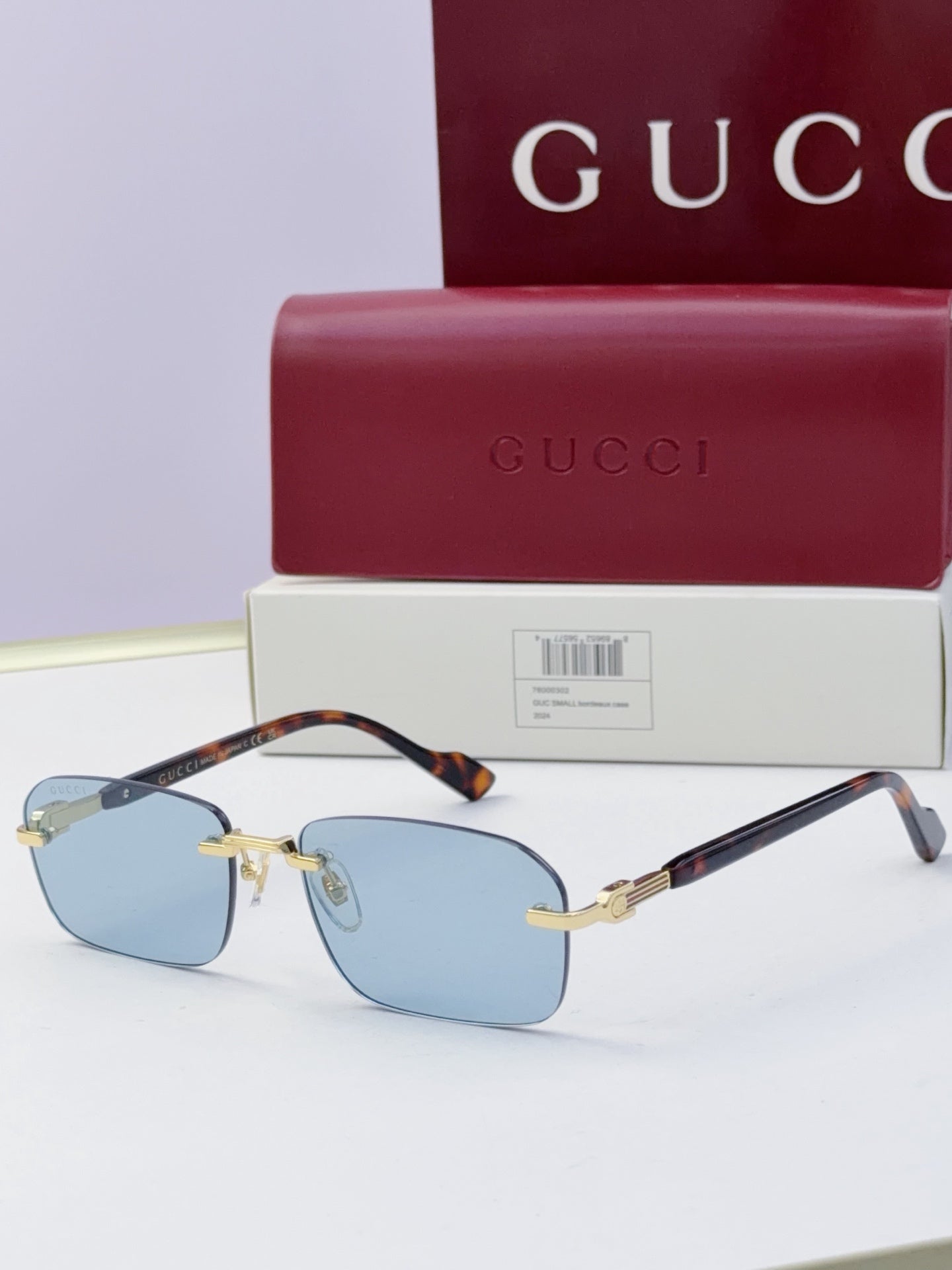 Gucci sunglasses with blue mirrored lenses, black temples, gold-tone frame hardware
