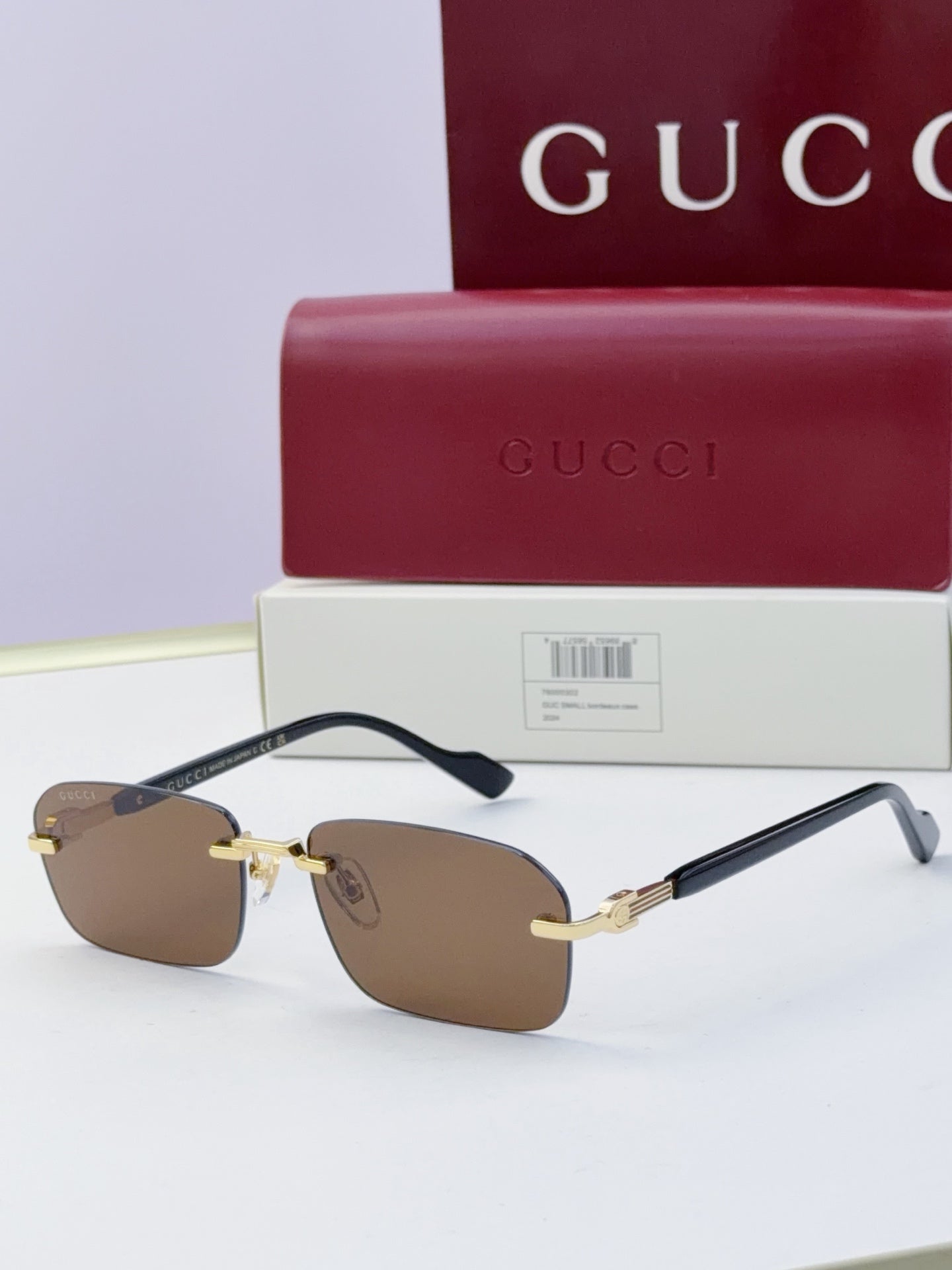 Gucci sunglasses with dark brown lenses, tortoiseshell temples, gold-tone frame hardware