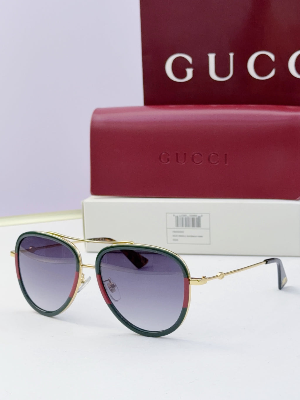 Gucci glasses with dark purple lenses and gold metal frames, round cat-eye style