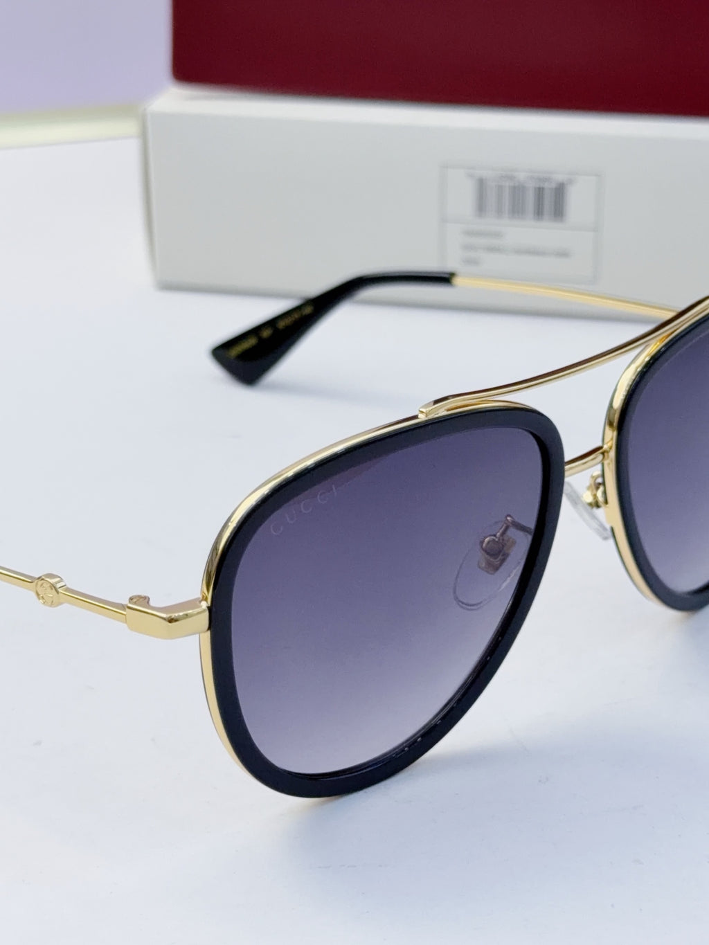 Gucci glasses with dark purple lenses and gold metal frames, side view with temples