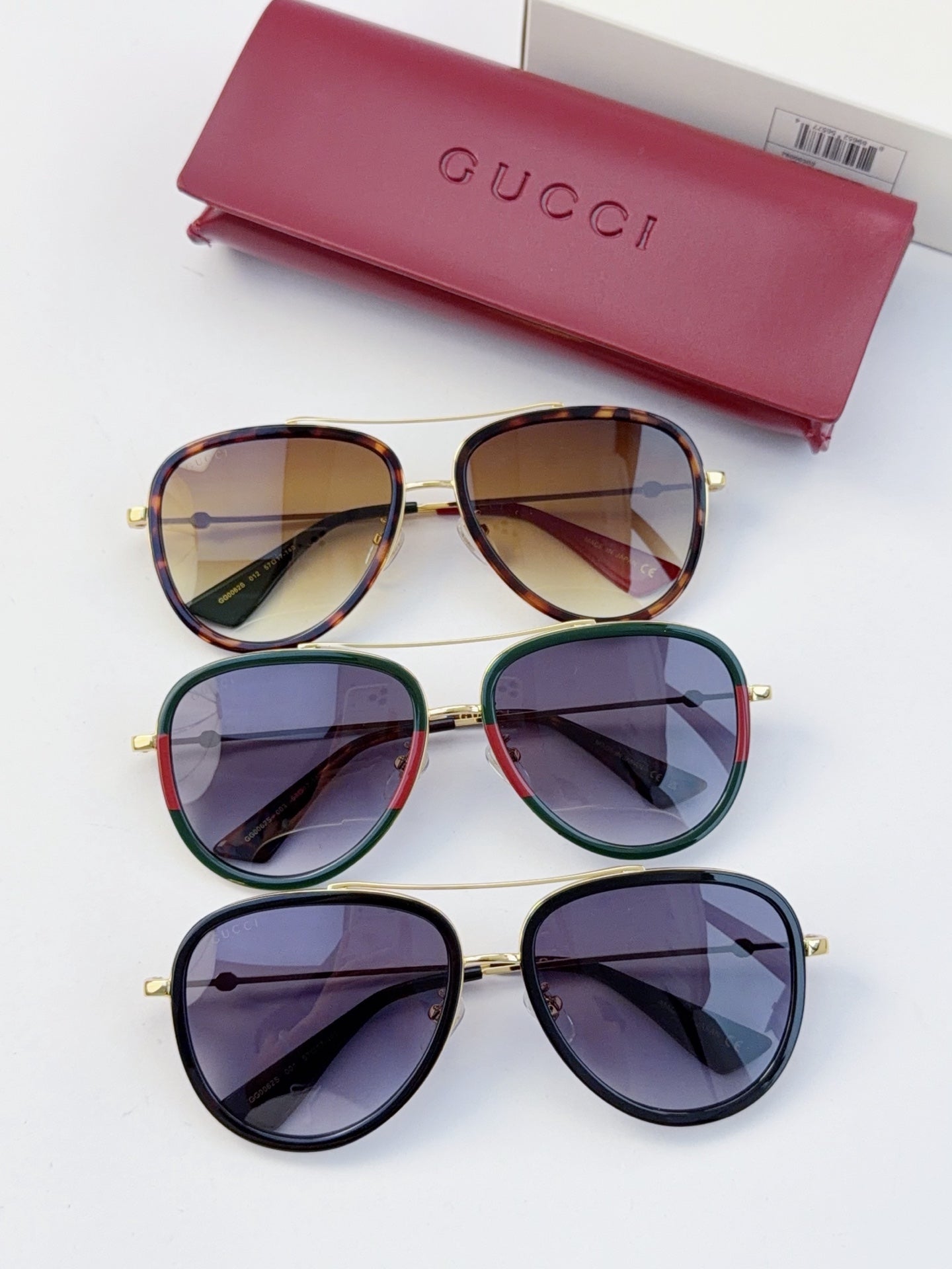 Gucci glasses set with three frame colors, purple lenses, and gold metal rims