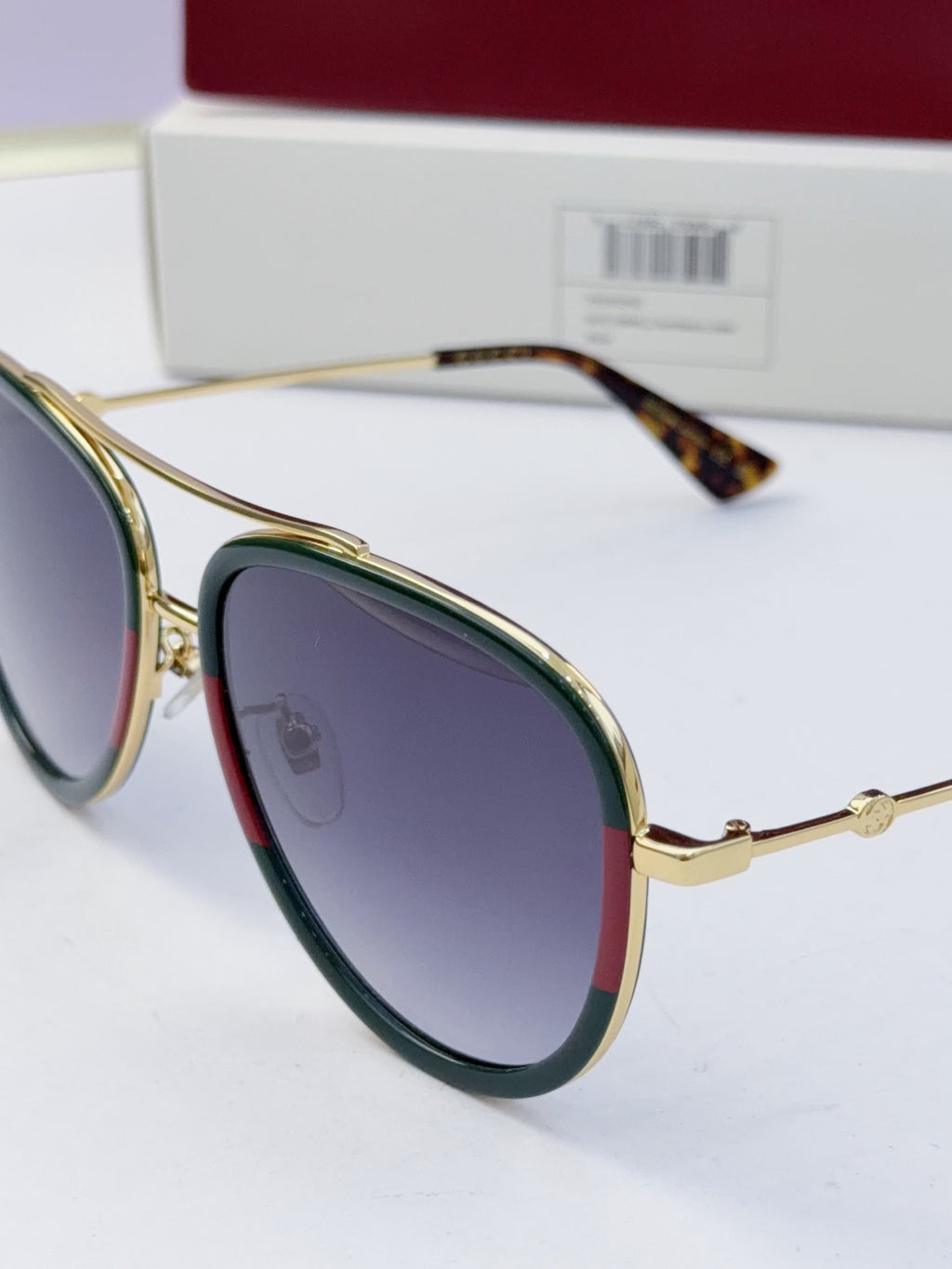 Gucci glasses with purple lenses and gold metal frames, angled view of both sides