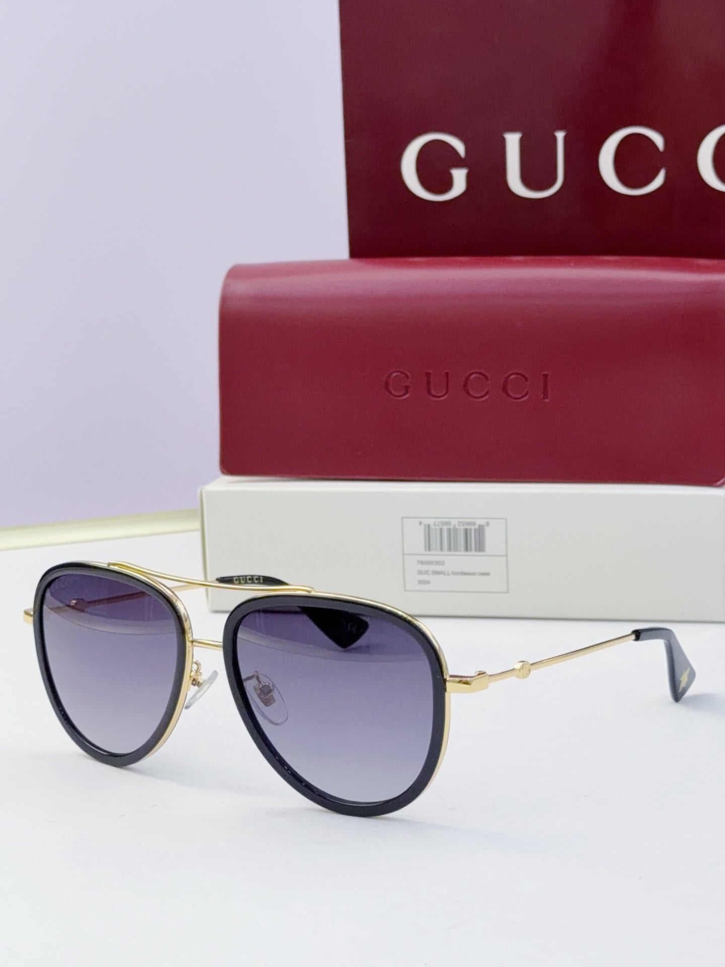 Gucci glasses with dark purple lenses and gold metal frames, round cat-eye style