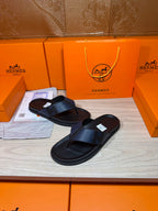 Black slide sandals with textured crossover straps and flat sole