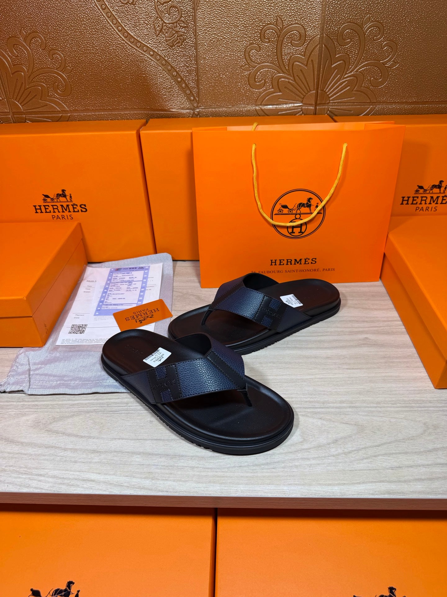 Black slide sandals with textured straps and flat rubber sole, angled