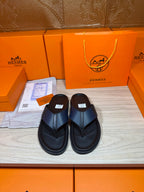 Black slide sandals with textured crossover straps and flat rubber sole