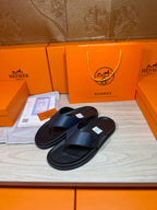 Black slide sandals with textured crossover straps, flat rubber soles