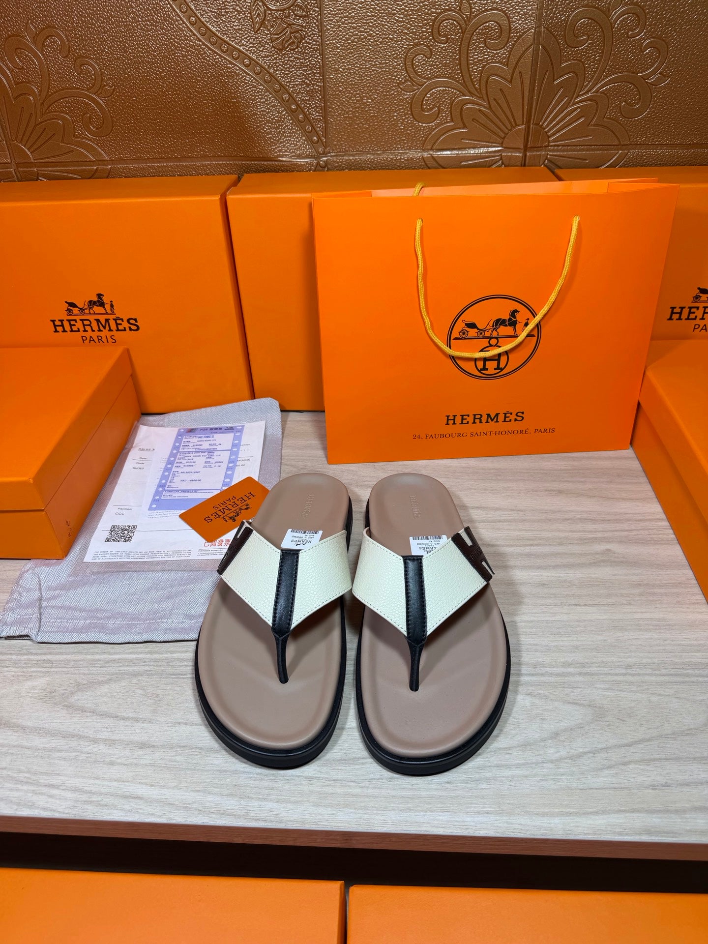 Luxury Hermes sandals with cream footbed, white strap, black H buckle detail