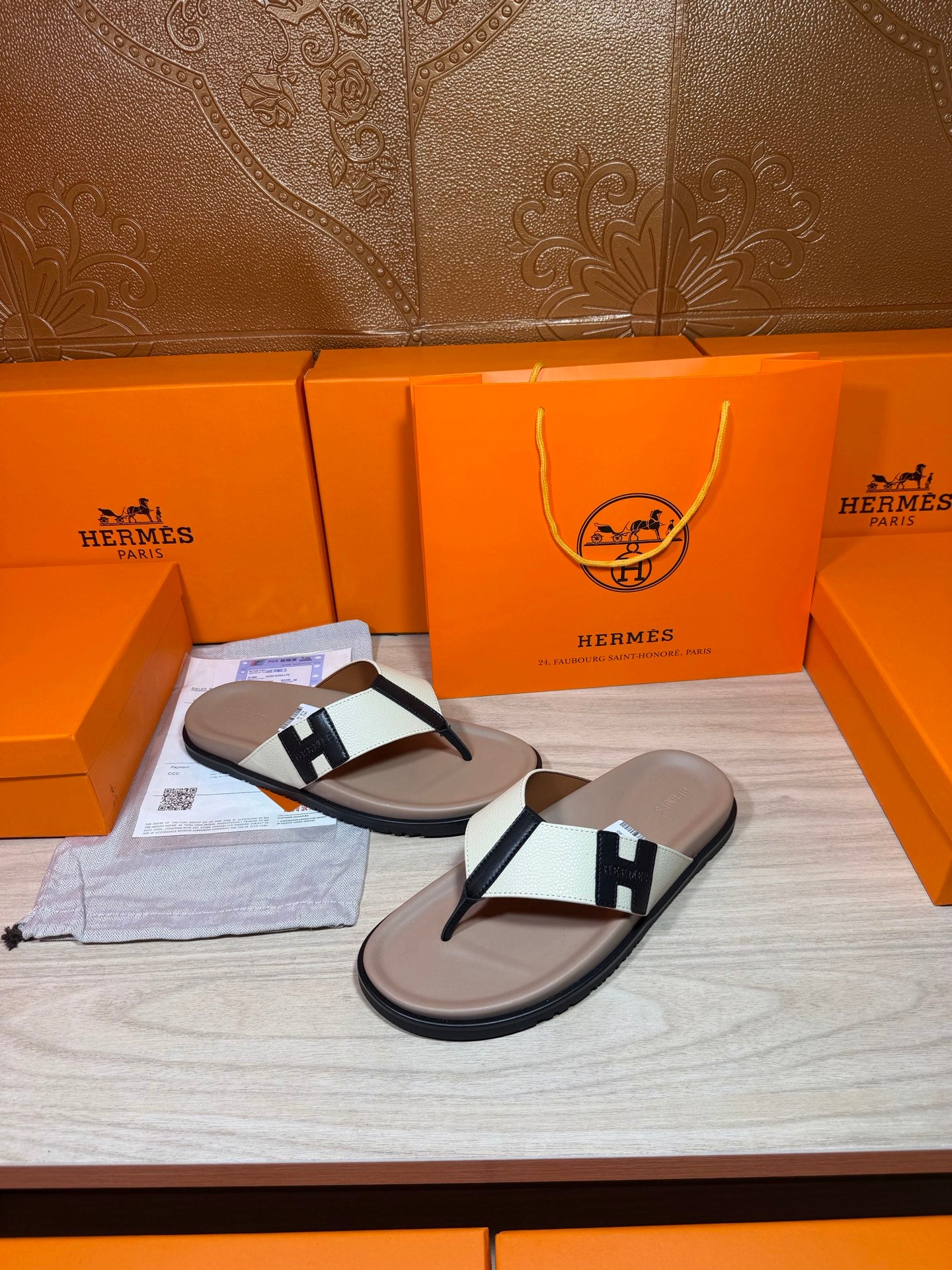 Luxury Hermes sandals with cream footbed and white strap over black thong straps