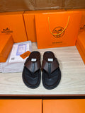 Black leather thong sandals with textured crossover strap and cushioned sole