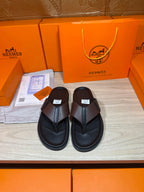 Black leather thong sandals with textured crossover strap and cushioned sole
