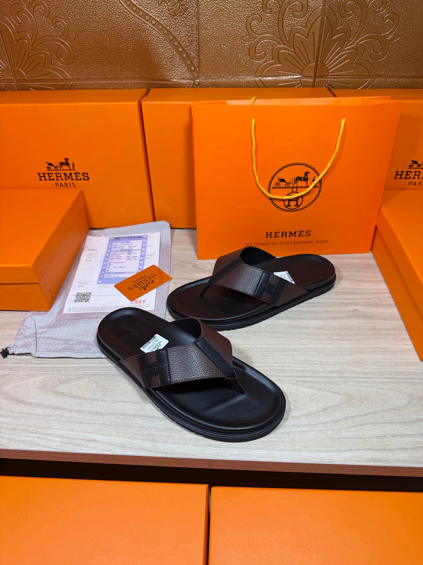 Pair of black leather thong sandals with textured crossover straps on display