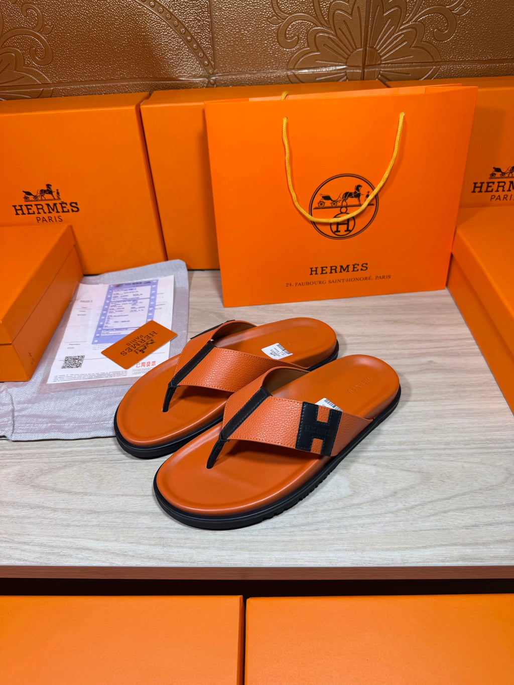 Hermes flip-flop sandals in orange leather with black H strap over toe post