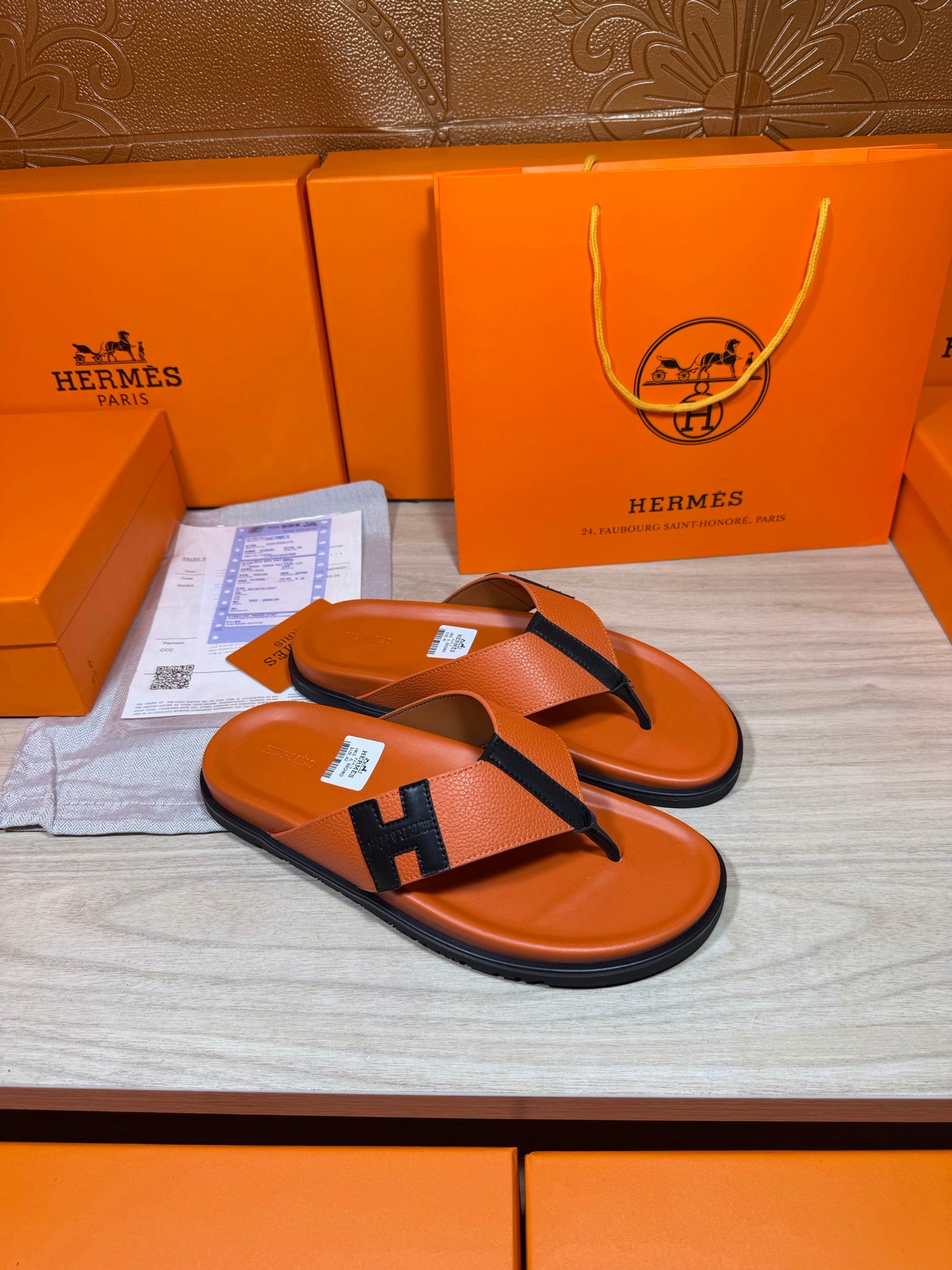 Orange and black Hermes slide sandals with H logo strap and curved toe thong