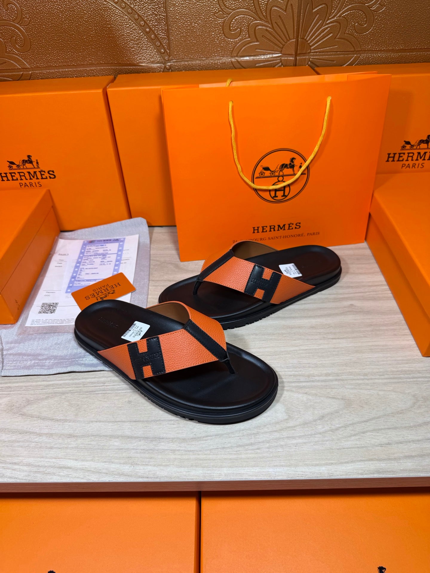 Orange stripe H sandals with black thong strap and padded footbed, flat.