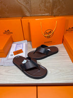 Pair of dark leather thong sandals with black strap detailing and flat sole