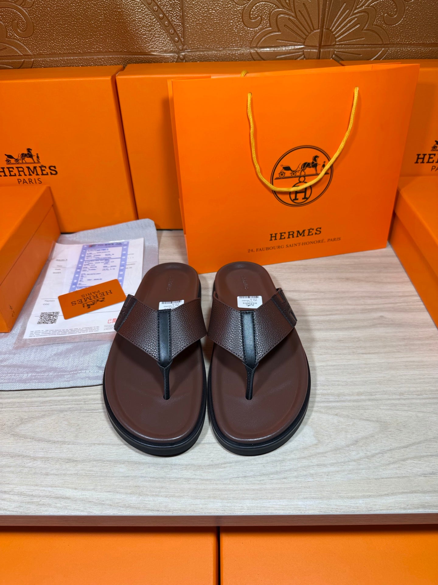 Dark leather sandals with two-strap flip-flop design and flat sole