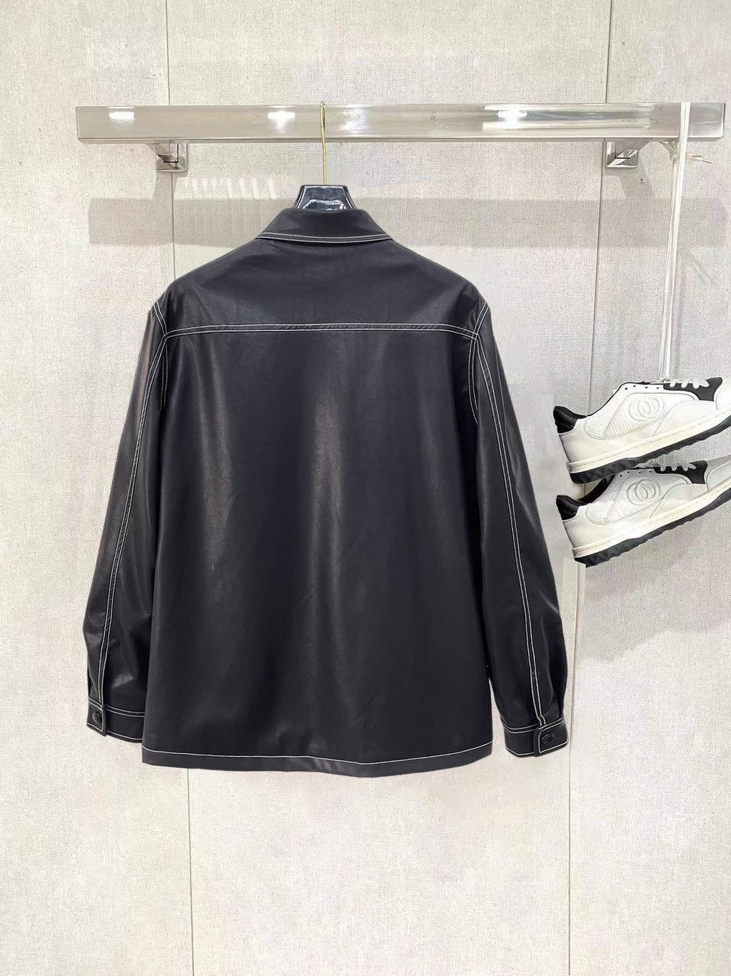Black leather jacket by Prada with stand collar and long sleeves
