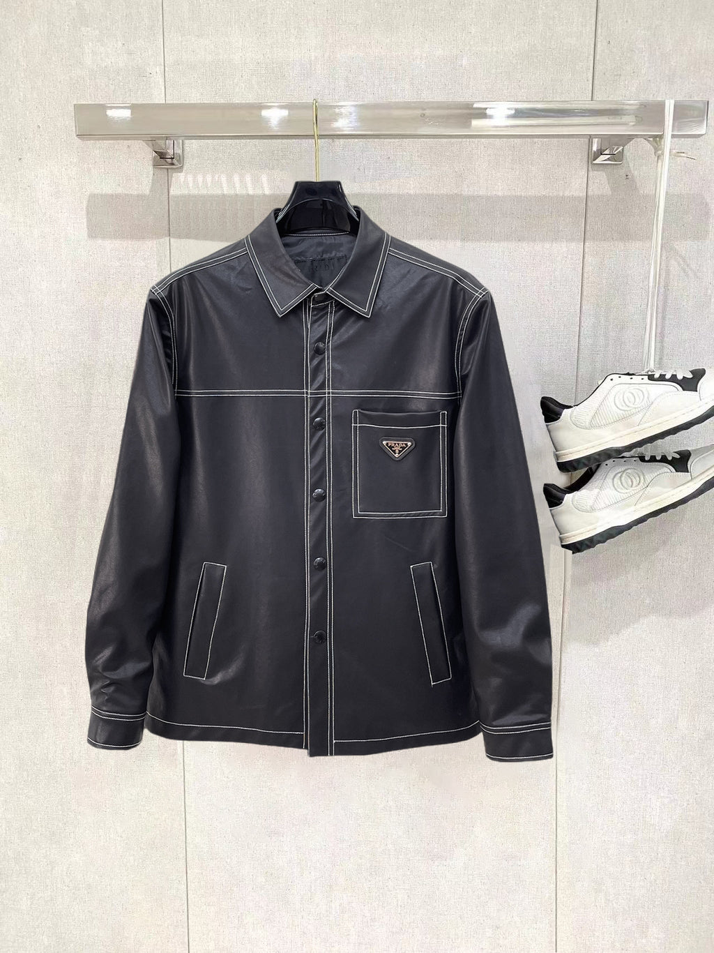 Leather jacket by Prada with stand collar, snap front, and chest pockets