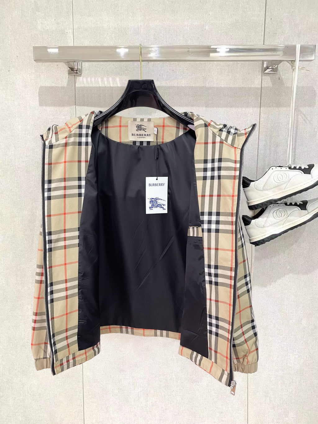 Reversible-style hooded jacket with black front and beige plaid sleeves