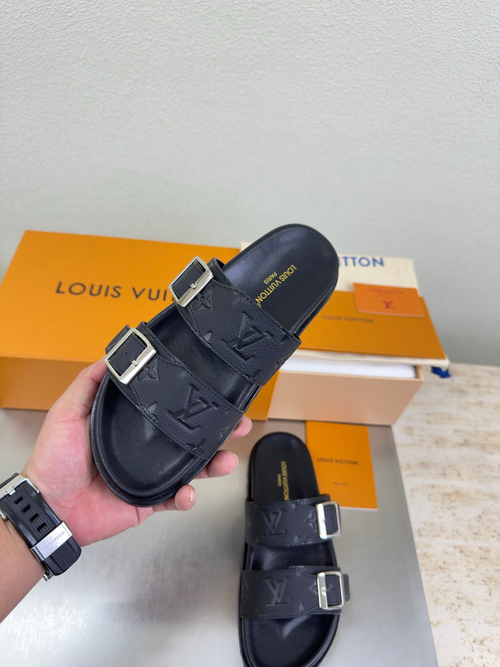 Louis Vuitton sandals in hand: dark LV monogram straps with silver square buckles