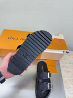 Louis Vuitton sandal sole in view with tread pattern; dark upper with silver buckle