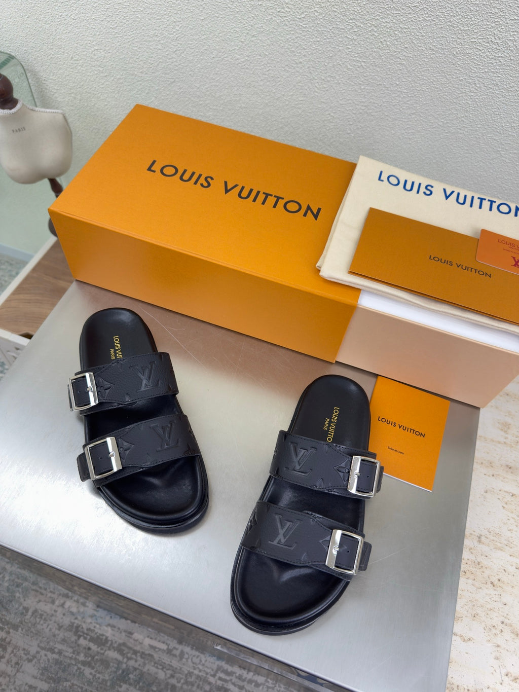 Louis Vuitton sandals with dark monogram straps, double bands, and silver buckles